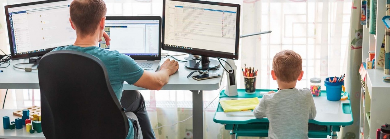 Vader met kind thuis aan het werken achter bureau