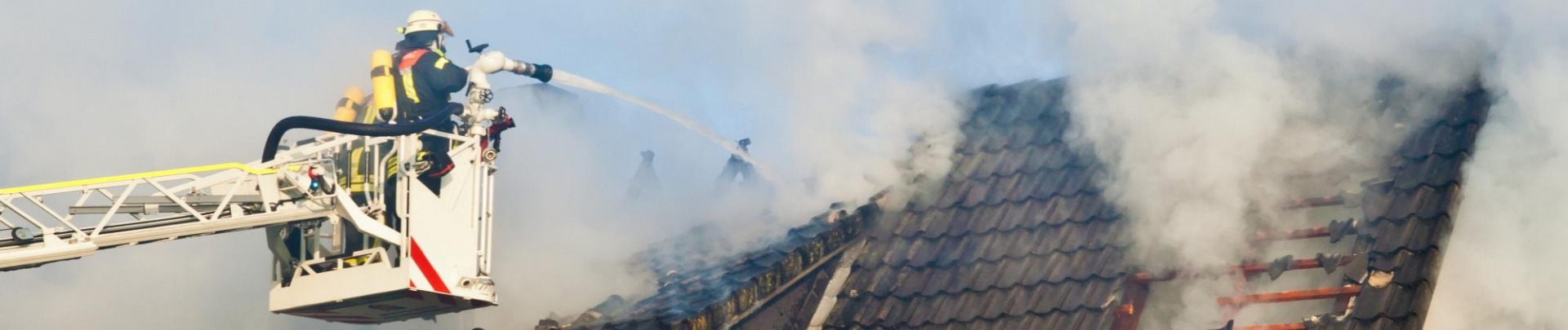Brandweerman is brand aan het blussen van een huis